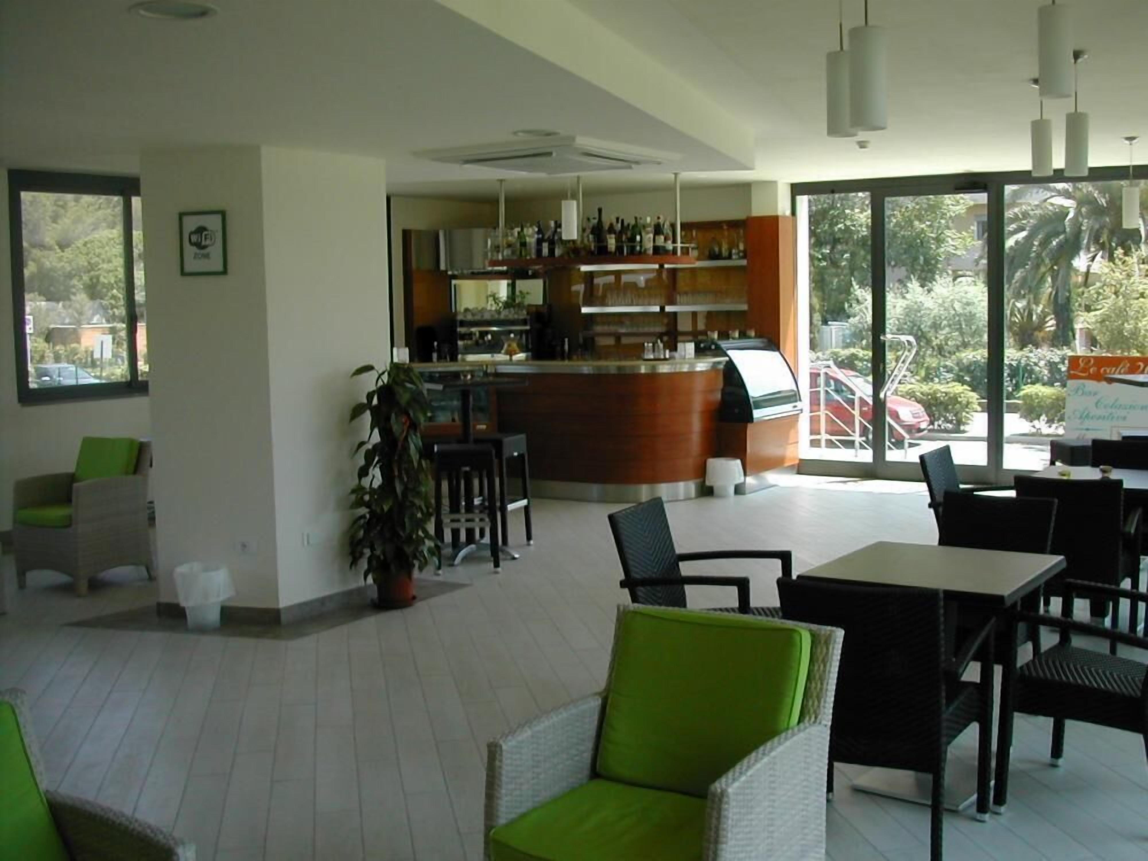 Un ristorante con un'area bar, posti a sedere e ampie finestre.