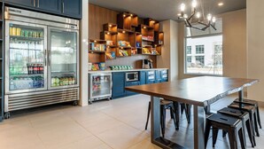 Una cocina moderna con encimera de mármol, estanterías empotradas y un refrigerador.