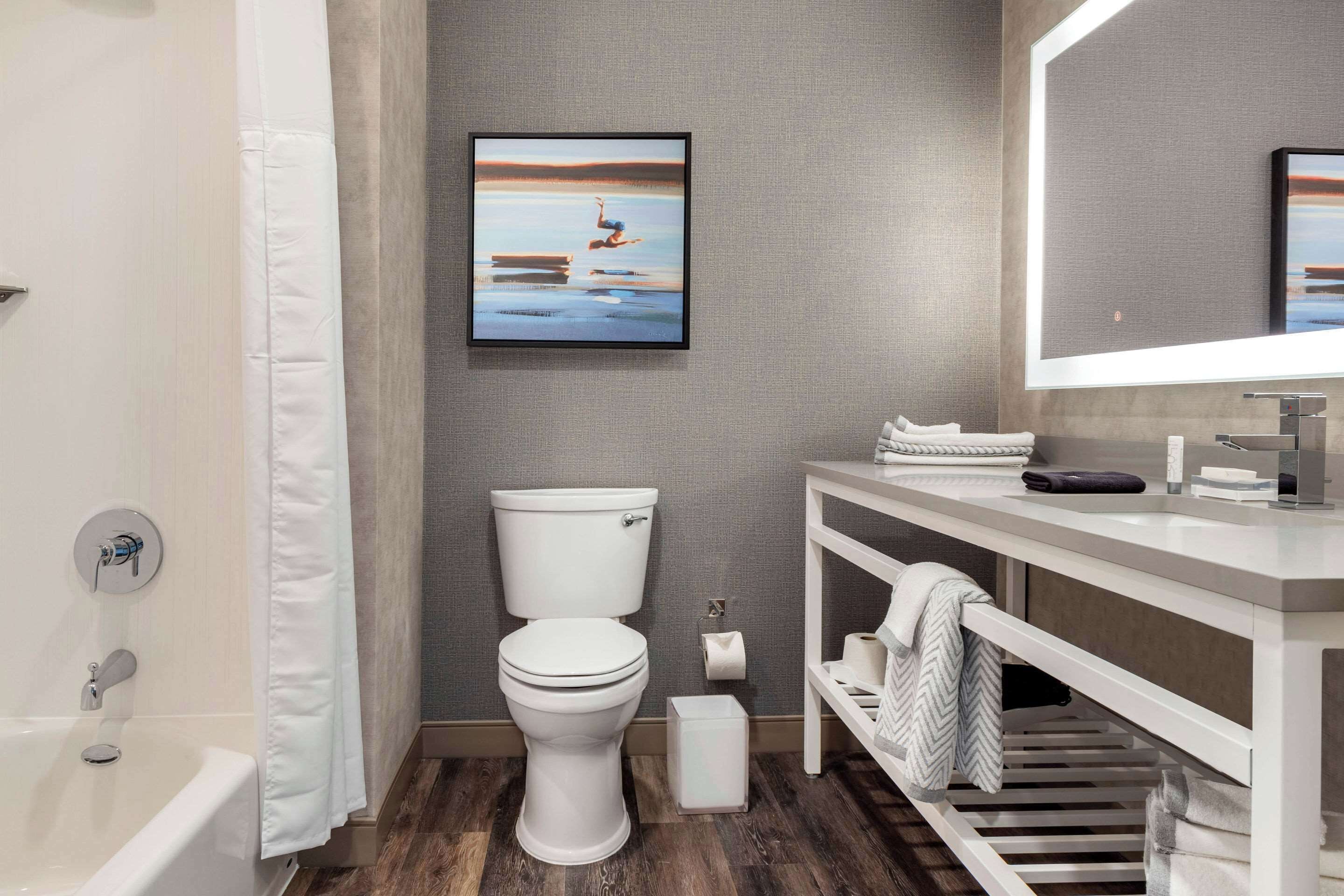 A modern bathroom with a toilet, sink, and bathtub.