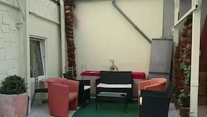 A small outdoor seating area with a table, two chairs, and a potted plant. - City Hotel-Garni (Hannover)