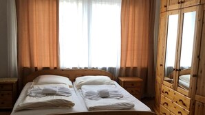 A double bed with white linens, wooden headboard, and two bedside tables. - City Hotel-Garni (Hannover)