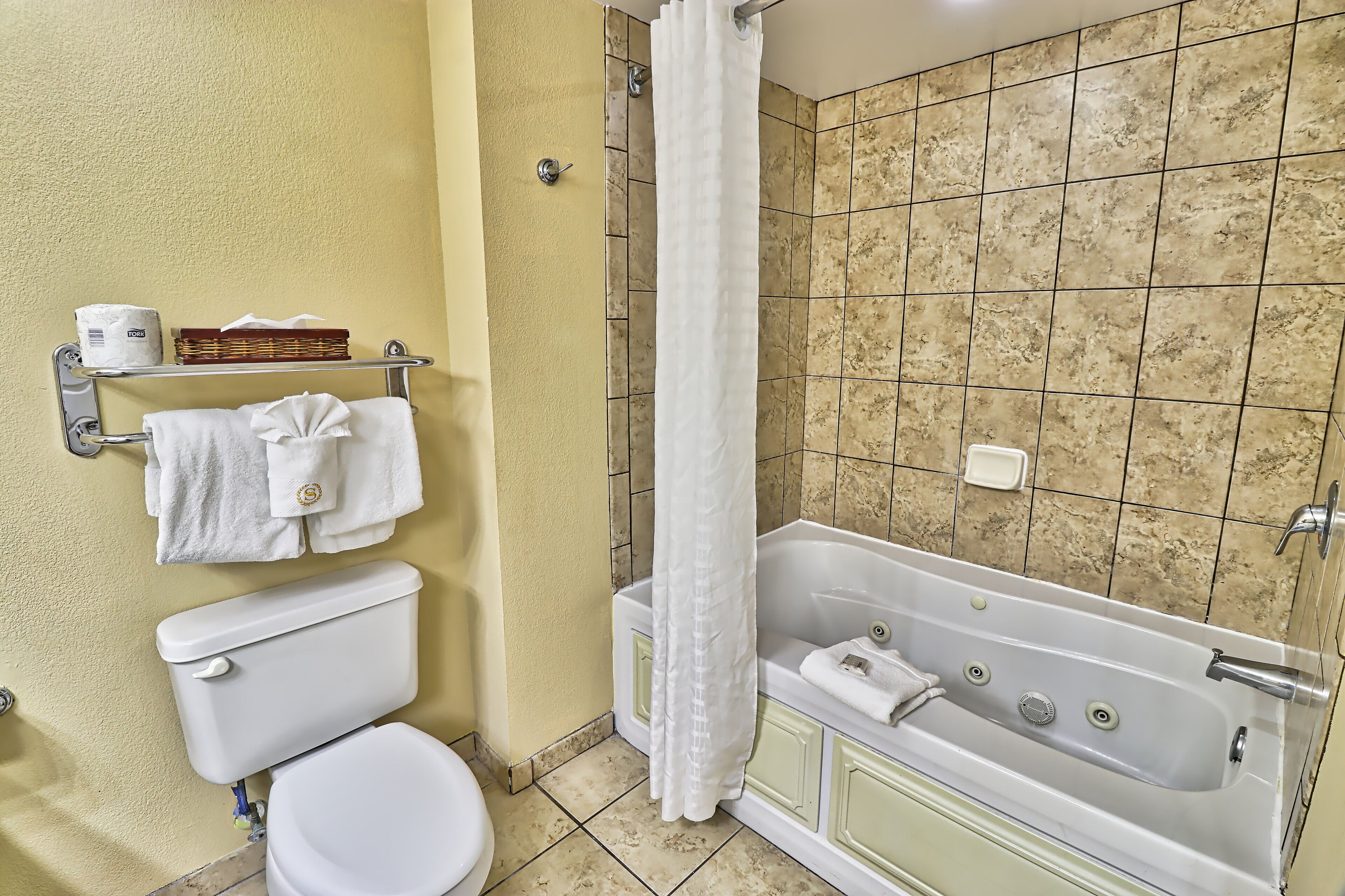 Ein Badezimmer mit Toilette, Badewanne und Duschvorhang.