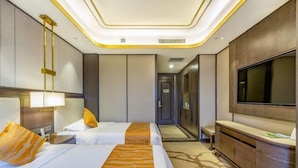 Une chambre d’hôtel avec deux lits, une télévision, un bureau et une armoire.