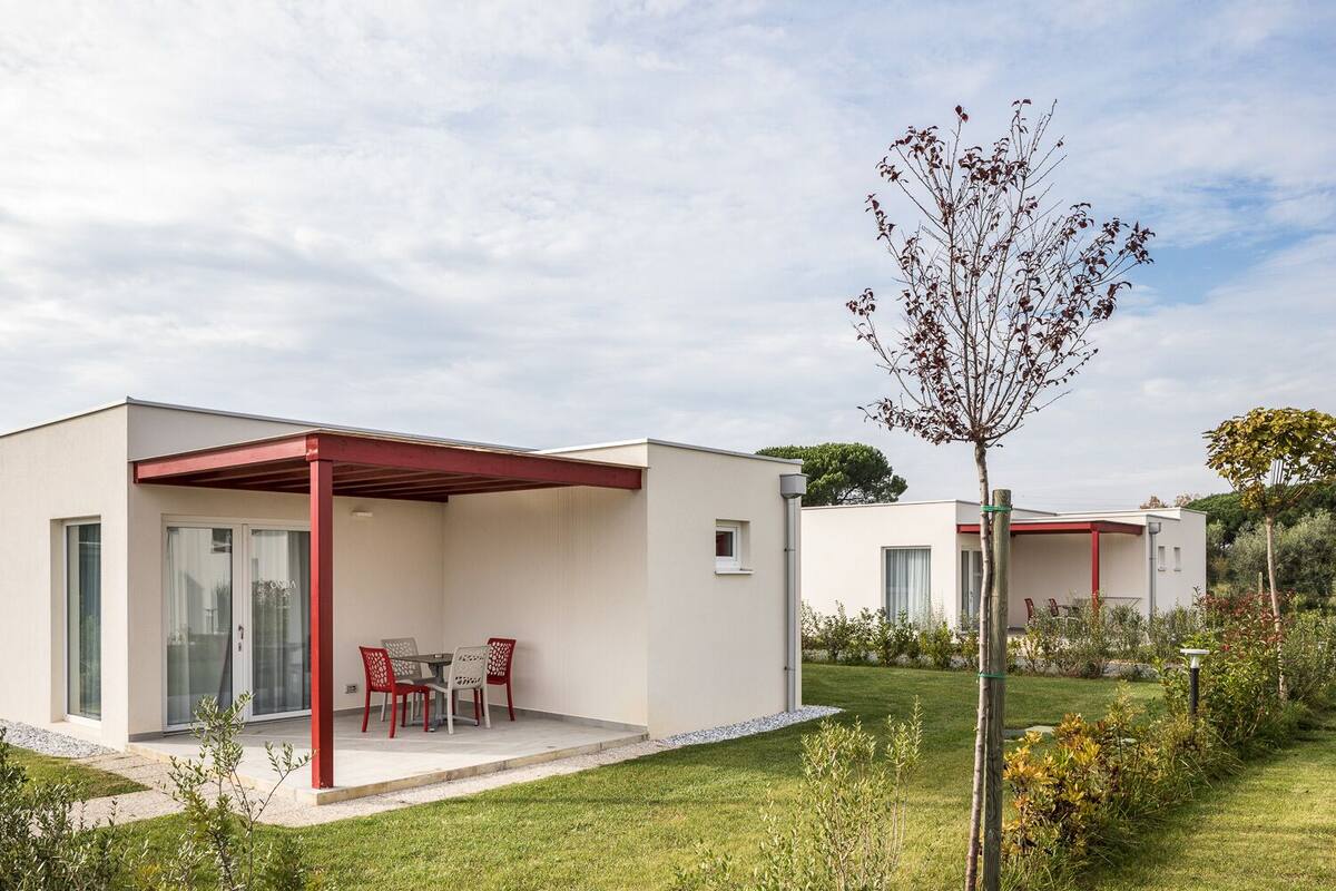 A modern two-story house with a covered patio and a small garden.