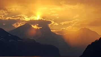 Un paysage de montagne avec une étendue d’eau qui reflète la lumière du soleil.