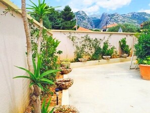 Un jardin sur le toit, agrémenté de plantes en pot, offrant une vue sur les montagnes.