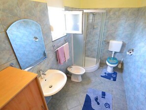 A bathroom with a sink, toilet, shower, and mirror. - Apartments Bucic (Starigrad)