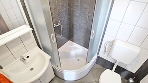 Un bany amb dutxa, rentapel, vàter i un penjallatowels.