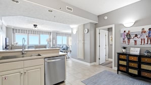 A spacious kitchen with a dishwasher, a large window, and a view of the ocean. - Relaxing Beachfront Condo with Beach Access - Unit 1603 by RedAwning (Panama City Beach)