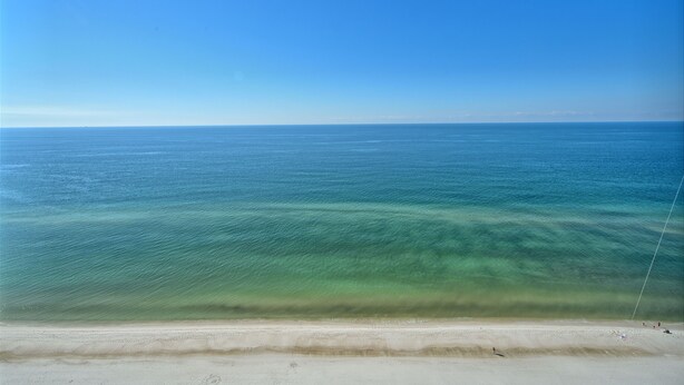 A beach with clear water and a sandy shore. - Roomy Oceanfront Condo with Breathtaking View and Beachside Pool - Unit 1906 by RedAwning (Panama City Beach)