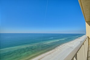 A beach view from a balcony with a clear sky and calm sea. - Roomy Oceanfront Condo with Breathtaking View and Beachside Pool - Unit 1906 by RedAwning (Panama City Beach)