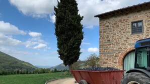 A stone building with a window and a tractor parked in front. - Villa Pie Vecchia in Chianti (Greve in Chianti)