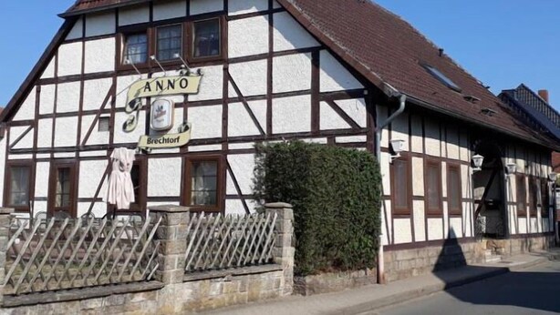 Ein traditionelles Fachwerkhäuschen mit einem Schild, auf dem "Anno Brechtorf" steht.
