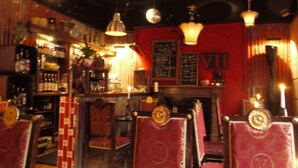A bar with red walls, vintage decor, and hanging lights. - 7 Houses (Armagh)
