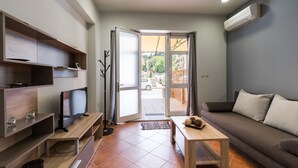 Una sala de estar moderna con una televisión de pantalla plana, estanterías empotradas, un sofá y una mesa de centro.