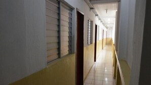 Un passadís amb sòls de rajola i portes que donen a habitacions.