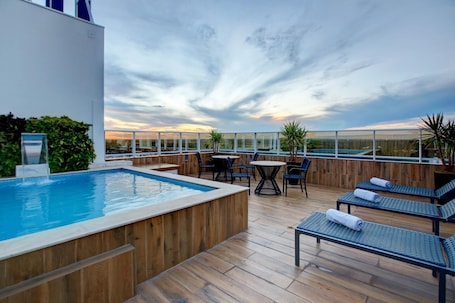 Una piscina al aire libre, sillones reclinables de piscina