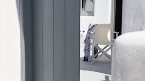 A white chair with a floral tablecloth outside a building. - Il Melograno Traditional Cave House (Santorini)