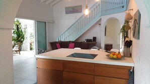 Une cuisine dotée d’un îlot central, d’un escalier et d’un coin repas.