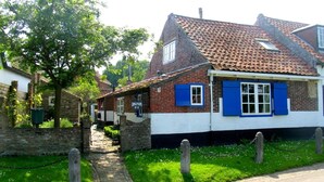 A traditional brick house with a tiled roof and blue shutters. - Charming house in Westenschouwen (Burgh-Haamstede)