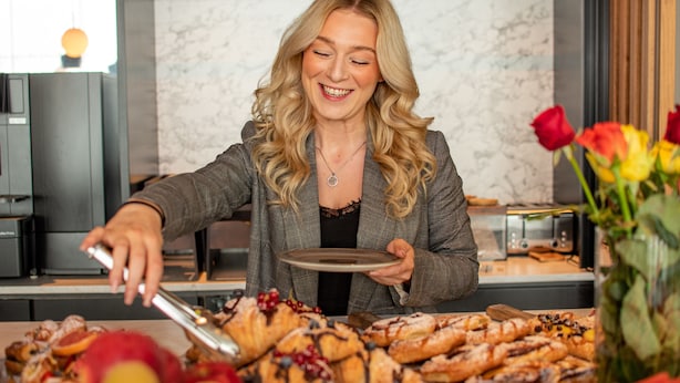Una mesa de buffet con diversas pastelerías y frutas.