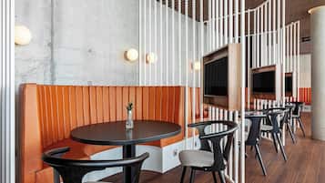 Un interior moderno con una mesa redonda, asientos acolchados y un techo de madera.
