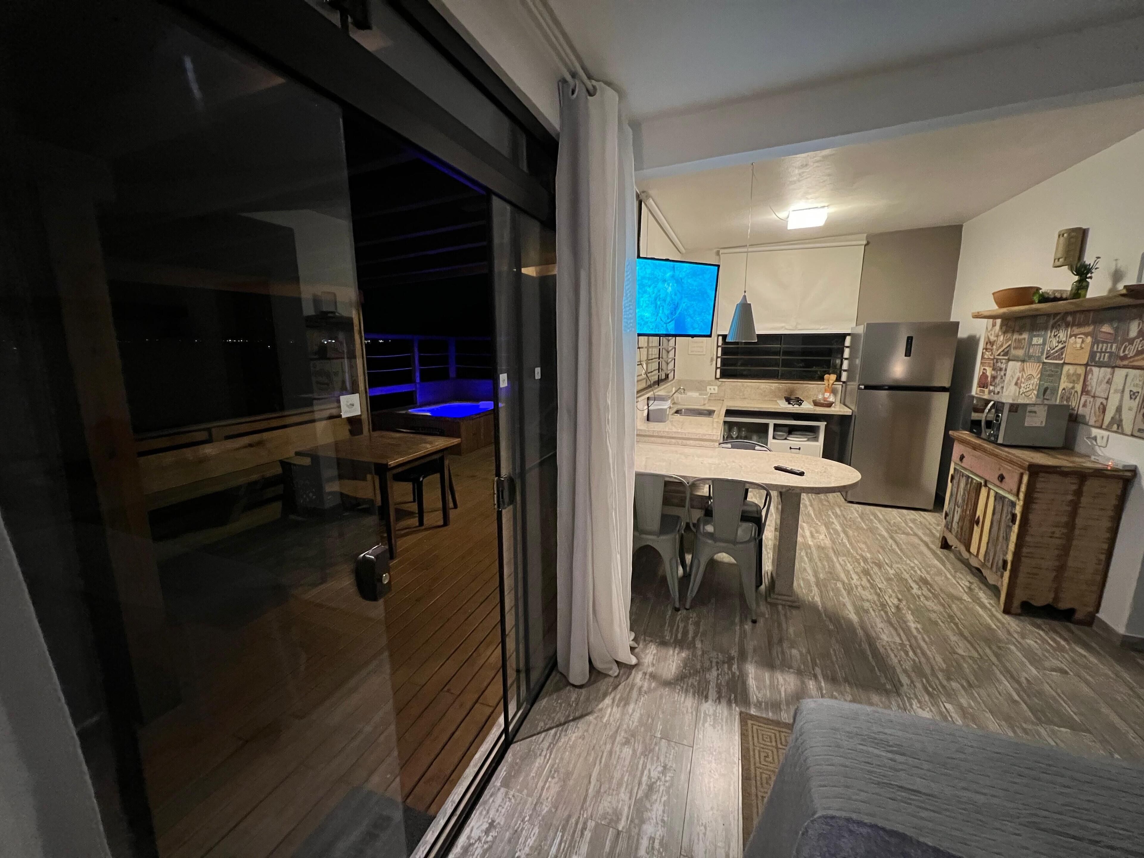 A modern kitchen with a built-in oven, a refrigerator, and a dining area with a table and chairs.