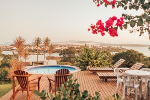 Una piscina al aire libre, sombrillas, sillones reclinables de piscina