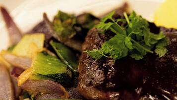 A close-up of a dish with mushrooms, green vegetables, and a garnish.