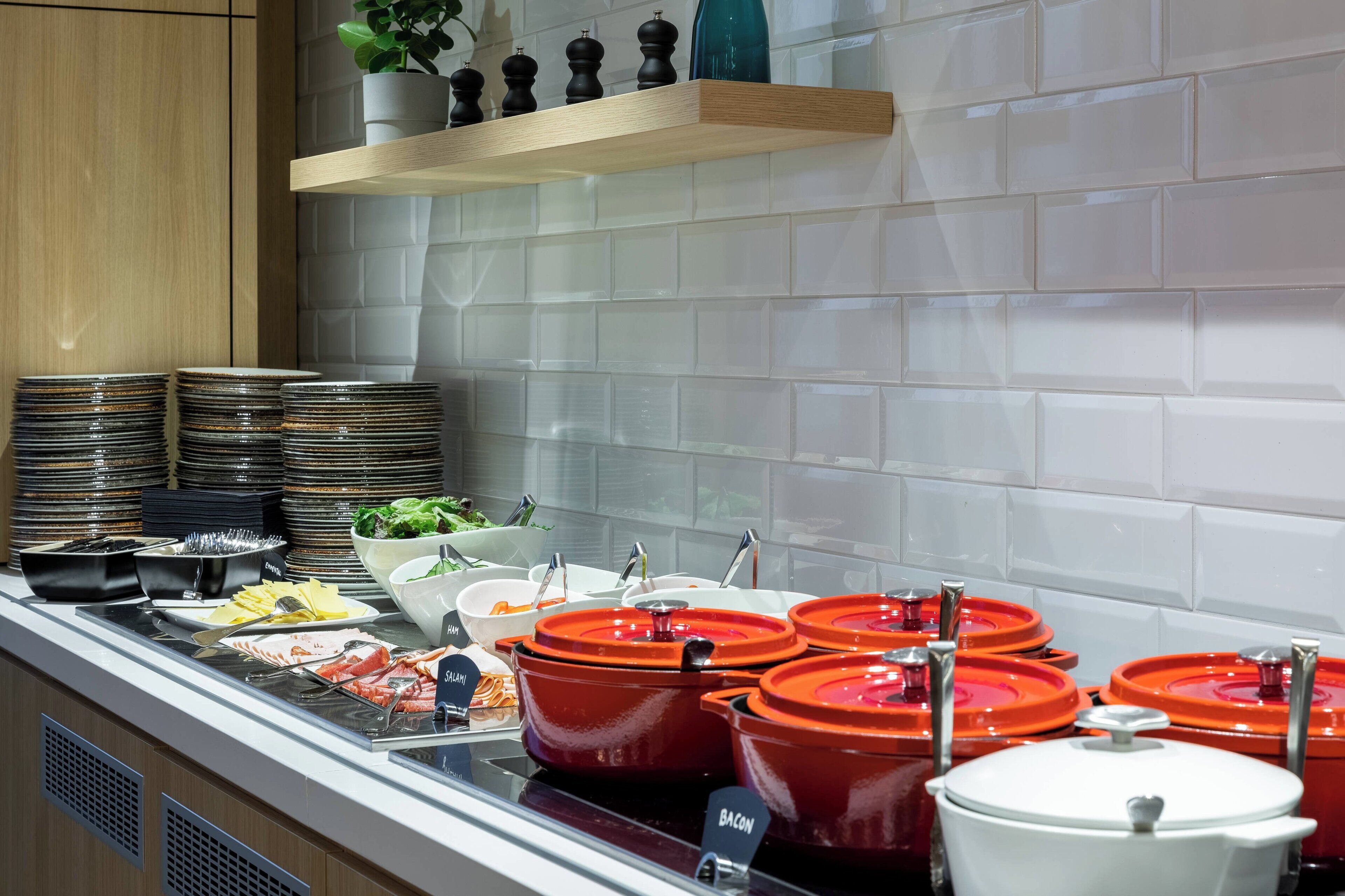 A buffet setup with various food items and serving utensils.