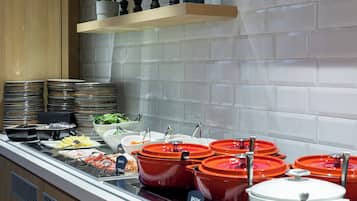 Una mesa de buffet con diversos alimentos y utensilios.