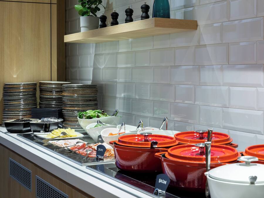 A buffet setup with various food items and serving utensils.