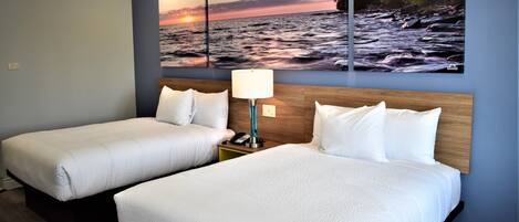 Two single beds with white bedding, a wooden headboard, a nightstand with a lamp, and a wall-mounted painting of a river scene.