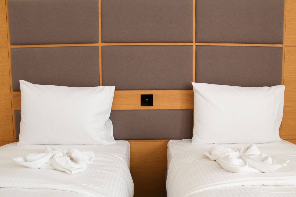 Ein Doppelbett mit Holz-Kopfteil und Bedienfeld.