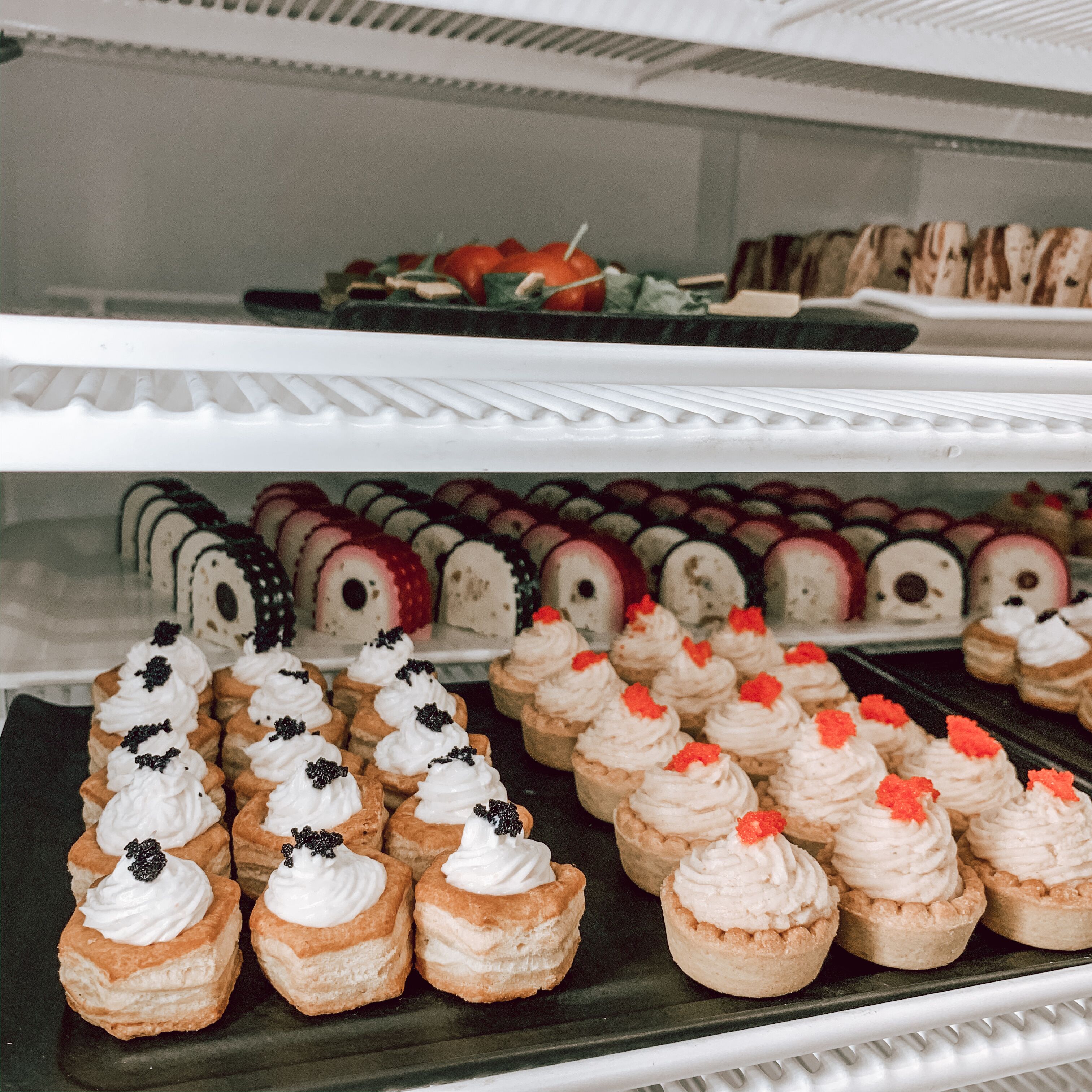 Een bakkerijdisplay met diverse gebakjes en desserts.