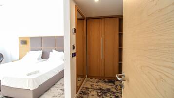 Une chambre d’hôtel avec un lit, une armoire en bois et une salle de bain avec douche.