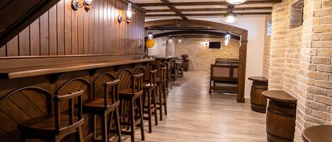 A bar area with wooden bar stools and a brick wall.