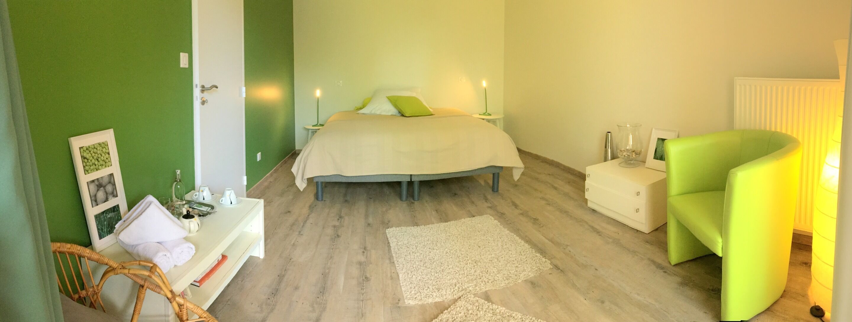 Een slaapkamer met een bed, nachtkastjes, een stoel en een nachttafeltje.