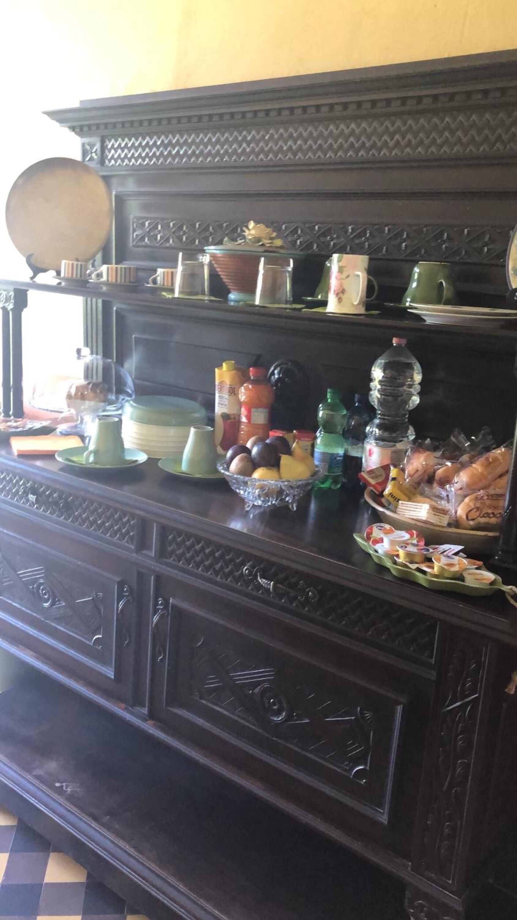 Un tavolo da buffet in legno scuro con diversi piatti e condimenti.
