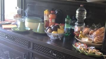 Un tavolo da buffet in legno scuro con diversi piatti e condimenti.