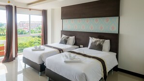 A hotel room with two beds, a large window with curtains, a view of greenery and buildings, and a modern headboard. - O2 Hotel Sakonnakhon (Sakon Nakhon)