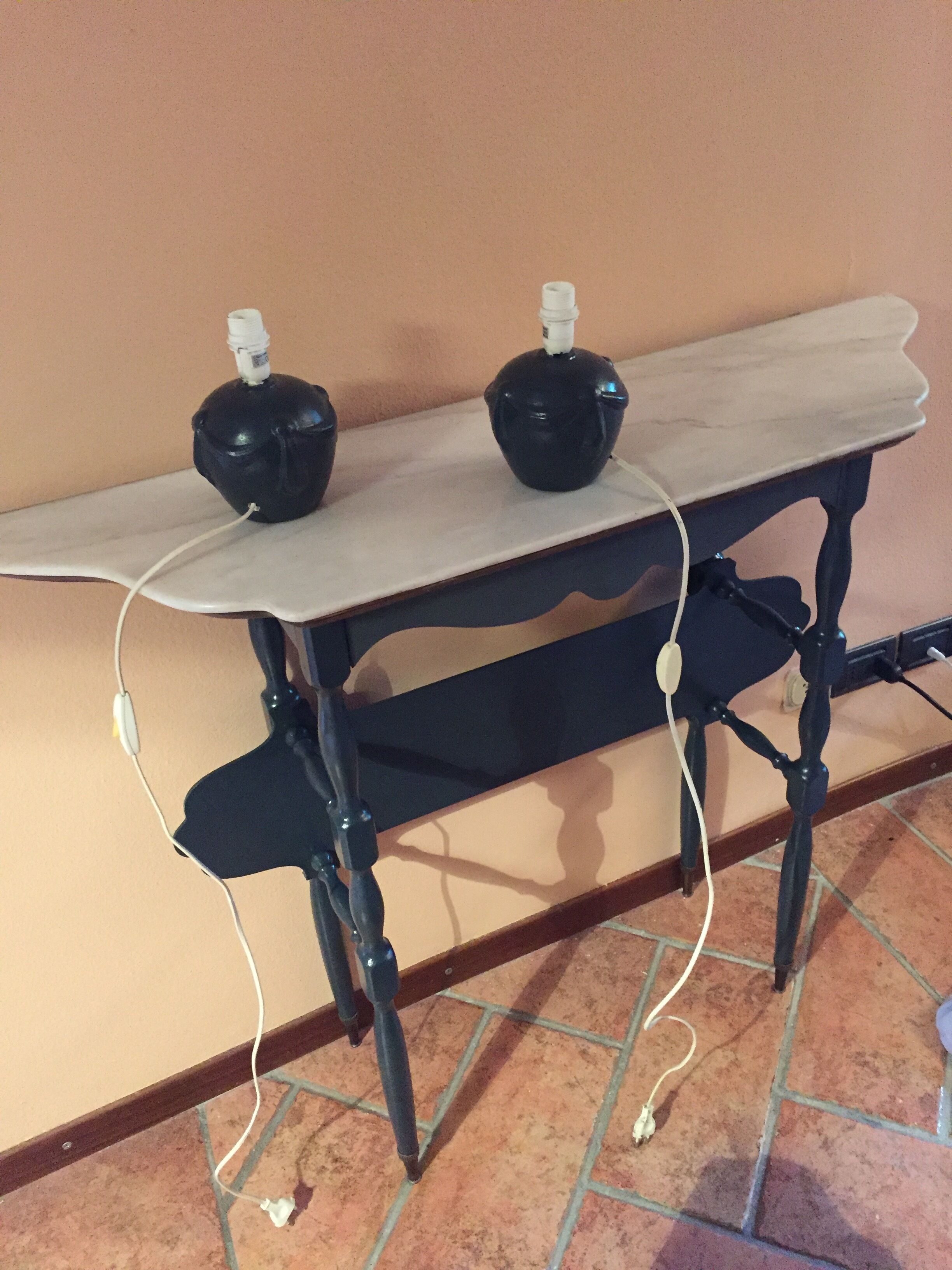 A table with two black objects on top, connected by white cables.