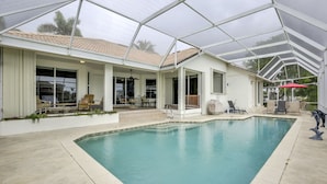 A covered swimming pool with a patio area, a covered patio, and a poolside lounge. - WIDE-VIEW ESTATE HOME NEAR BOAT RAMP WITH POOL & DEEP-WATER DOCKAGE (Marco Island)