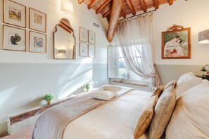 A bedroom with a large bed, a window with sheer curtains, and artwork on the walls. - RENAISSANCE WINERY VILLA AMONG THE VINEYARDS, 9 BEDROOMS, 7 BATHS, WIFI, AIR CON (Lucca)