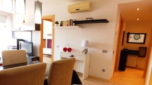 A modern kitchen with a dining area, featuring a wooden table, chairs, and a built-in bookshelf. - A207 Apartment in the center of Roses with private parking, near the beach of Roses (Roses, Girona)