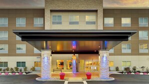 A hotel entrance with a covered walkway, multiple windows, and a stone facade. - Holiday Inn Express Middletown-Goshen (Middletown)