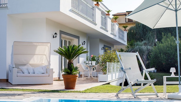 A poolside area with a white lounge chair, a sun umbrella, and a potted plant. - Villa Lia (Sant'Agnello)