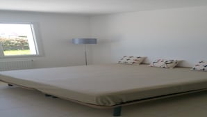 A bedroom with a bed, a window, and a floor lamp. - House of 50 m2 living space with large landscaped garden (Vineuil)