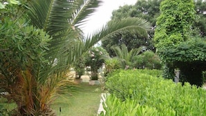 A lush garden with various plants and a pathway. - HRS Hotel Sabatino (Follonica)