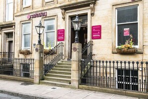 A building with a 'Safestay' sign, a staircase, and a wrought iron fence. -  Roam Glasgow (Glasgow)